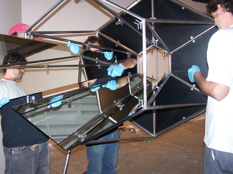 Technicians assembling a suspended geometric sculpture